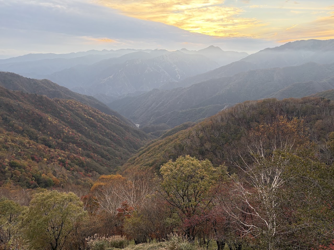 何層にも重なる山々の向こうに沈んでいく夕日